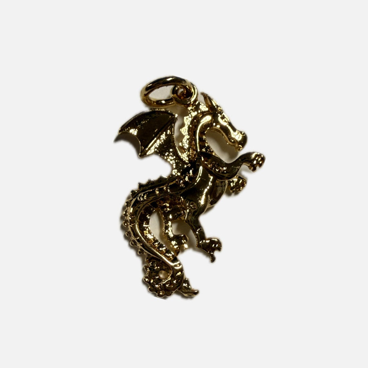 Gold dragon-shaped pendant on a white background