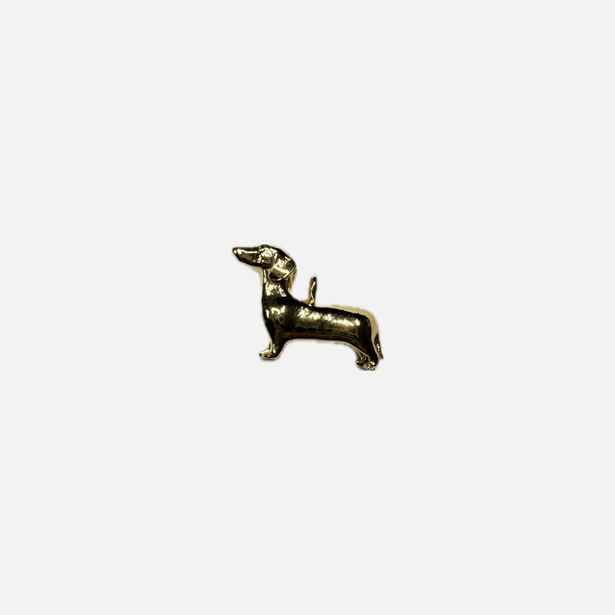 Gold dachshund charm on a white background