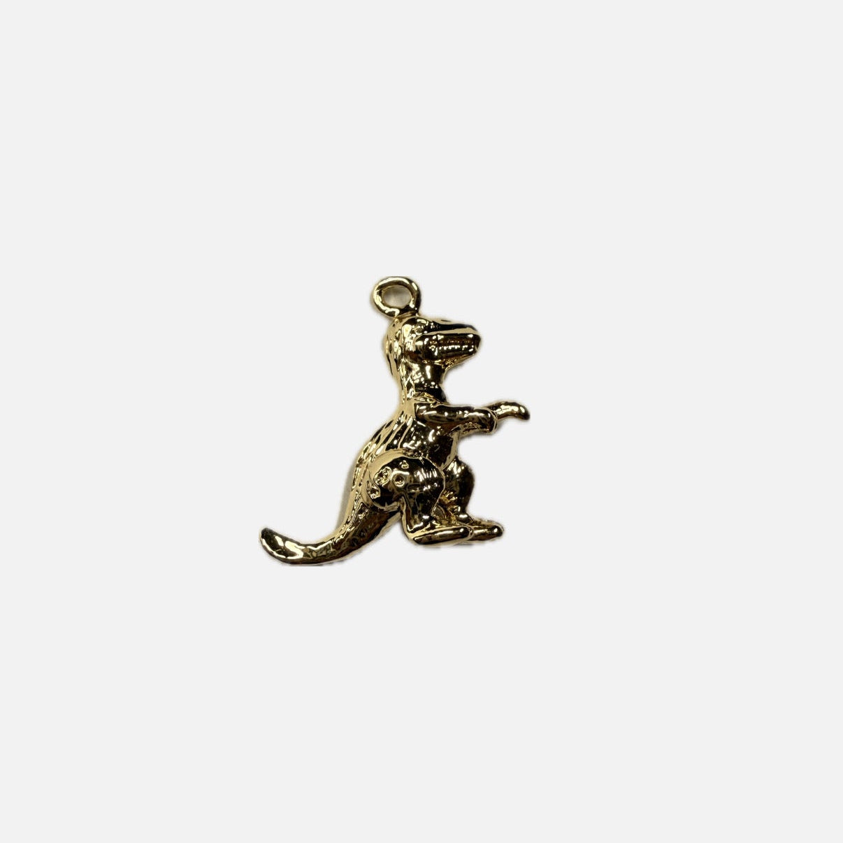Gold dinosaur pendant on a white background
