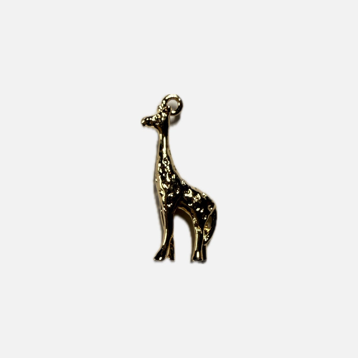 Small gold giraffe charm on a white background