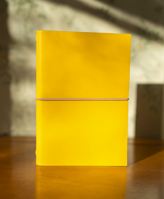 Yellow leather journal on wood with a blurred background